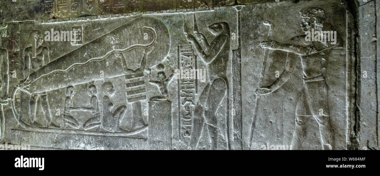 Relief sur le mur nord de la crypte souterraine, sud 1 C, dans le temple d'Hathor. Illustrant l'UPU, avec le visage d'un crapaud, couteaux holding Banque D'Images
