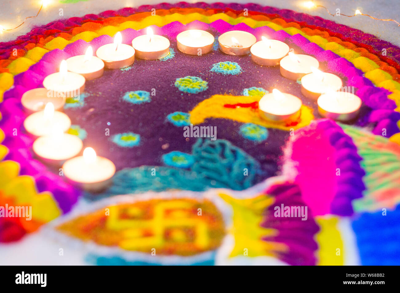 Belle rangoli fabriqués à partir de poudres colorées et décorées de bougie de cire de diyas sur diwali eve. Ces modèles sont fabriqués à la main par les hindous et décorer Banque D'Images
