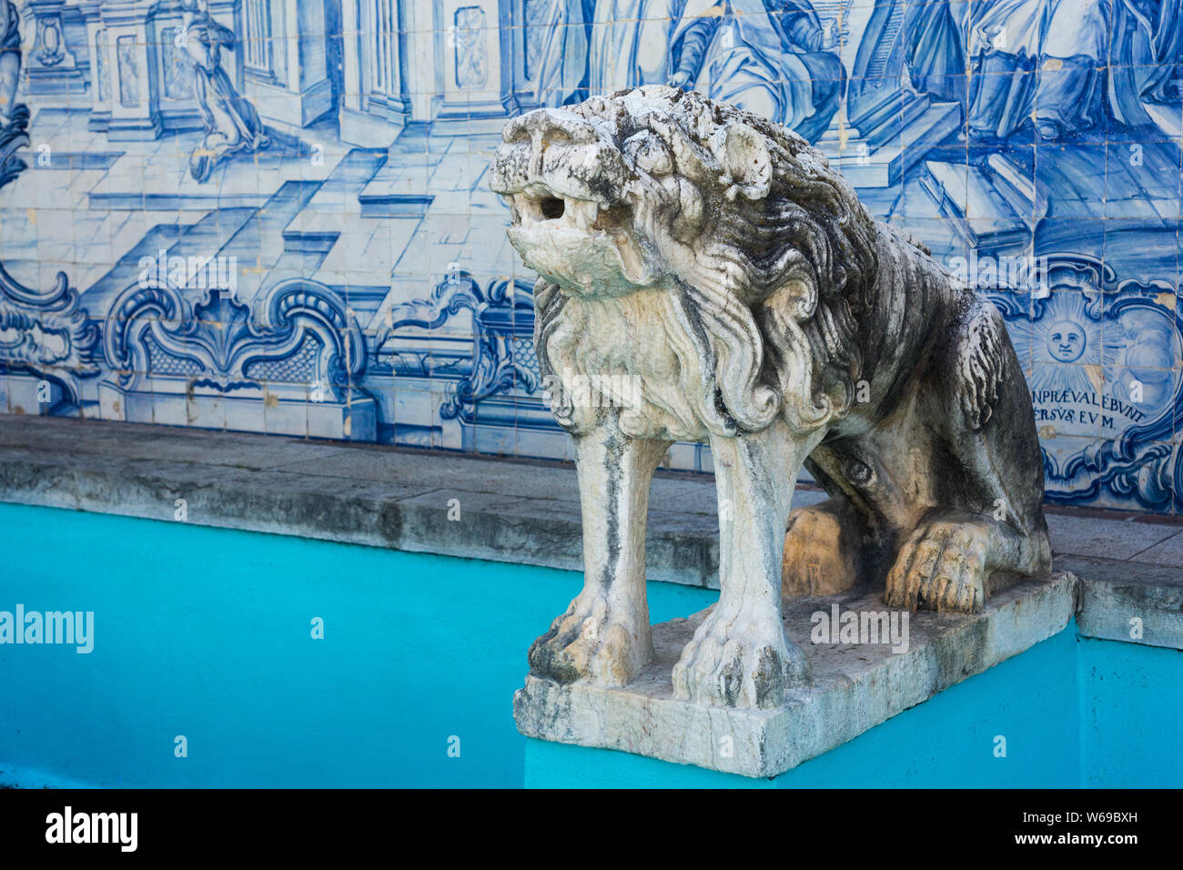 Bec d'eau de lion en pierre ornementale dans une belle fontaine avec des tuiles pittoresques peintes en bleu au Parque Marechal Carmona (parc) Cascais, Portugal. Banque D'Images