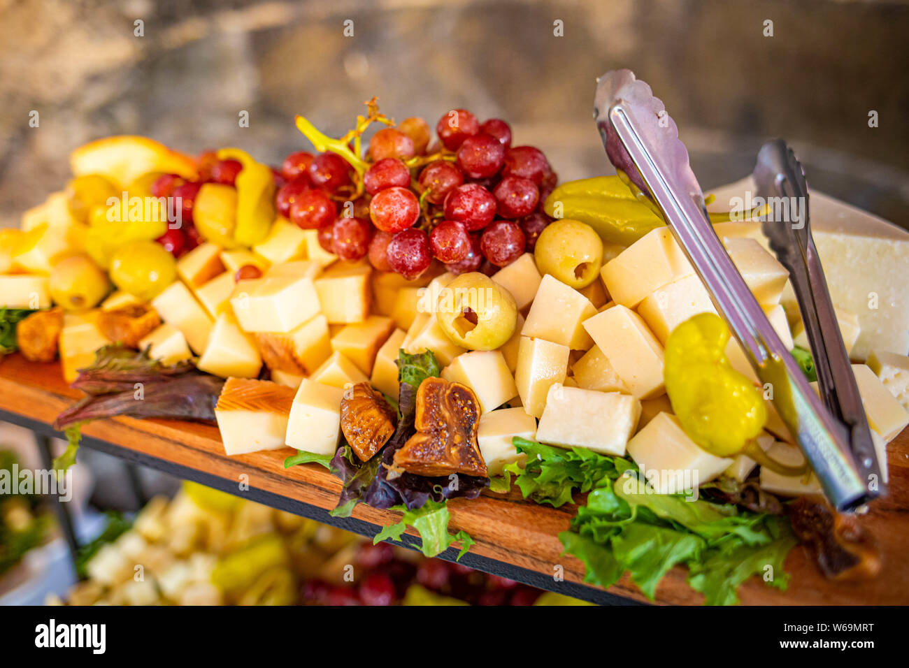 Variation fromage plaque avec les raisins et les olives sur la table Banque D'Images