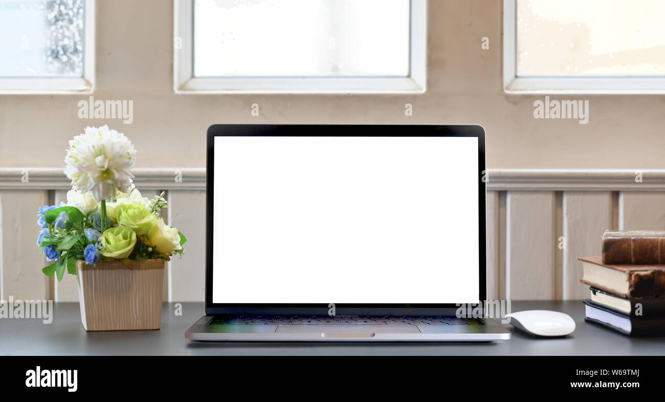 Ordinateur portable écran blanc sur noir 24 dans un salon confortable avec décorations Banque D'Images