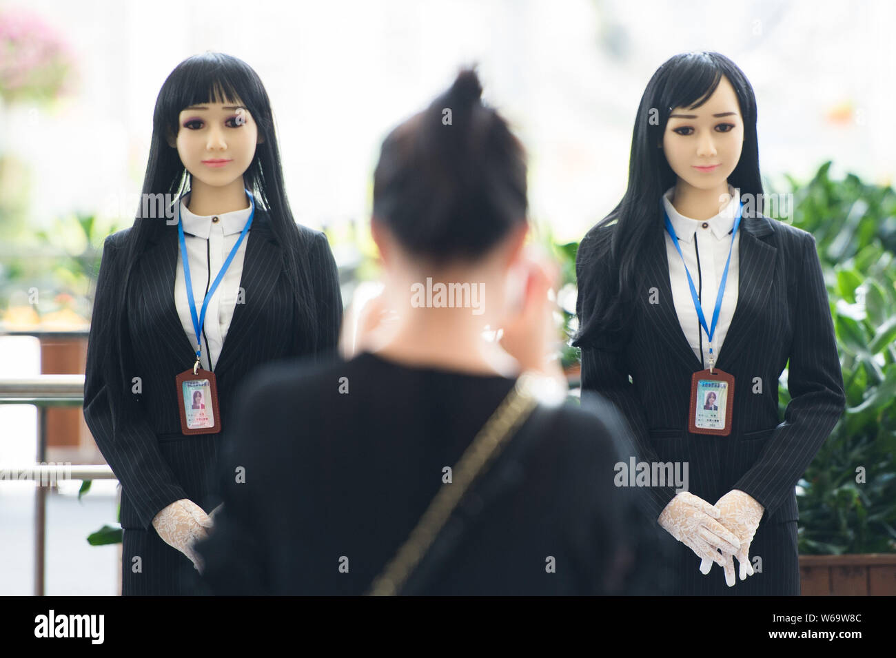 Un passager prend des photos de robots humanoïdes utilisés pour sensibiliser le public à la lutte contre la drogue s'affiche sur la Journée internationale contre l'abus et Illi Banque D'Images