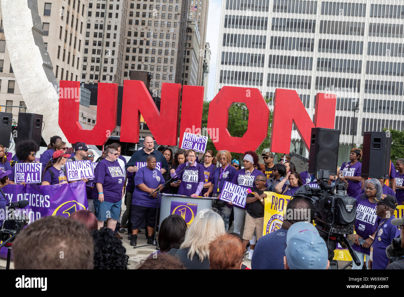 Detroit, Michigan - les gardes de sécurité à édifices du centre-ville de l'homme d'affaires Dan Gilbert rassemblement à l'héritage du travail monument dans le cadre de leur campagne Banque D'Images