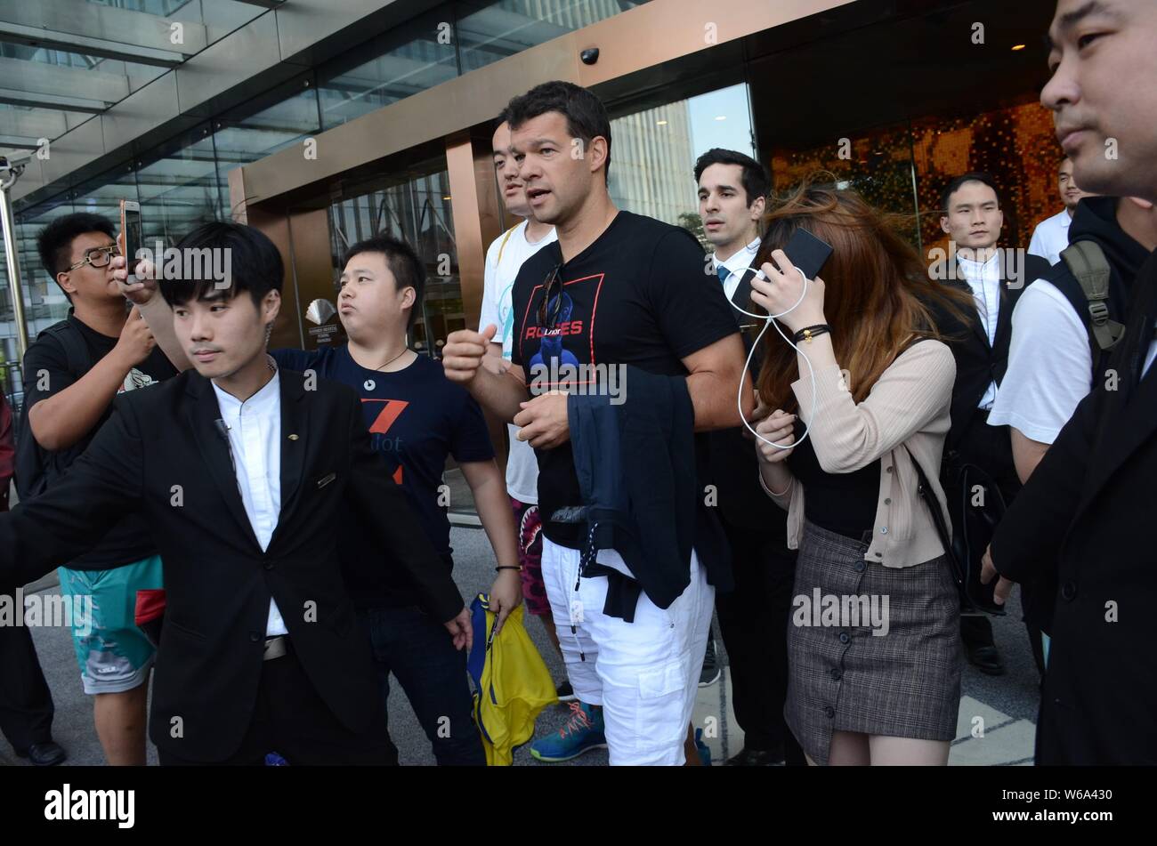 Ancien joueur allemand Michael Ballack, plus haut, est entouré par des fans et des gardes du corps alors qu'il sort d'un hôtel avec sa petite amie Natacha Tannous dans Shangh Banque D'Images