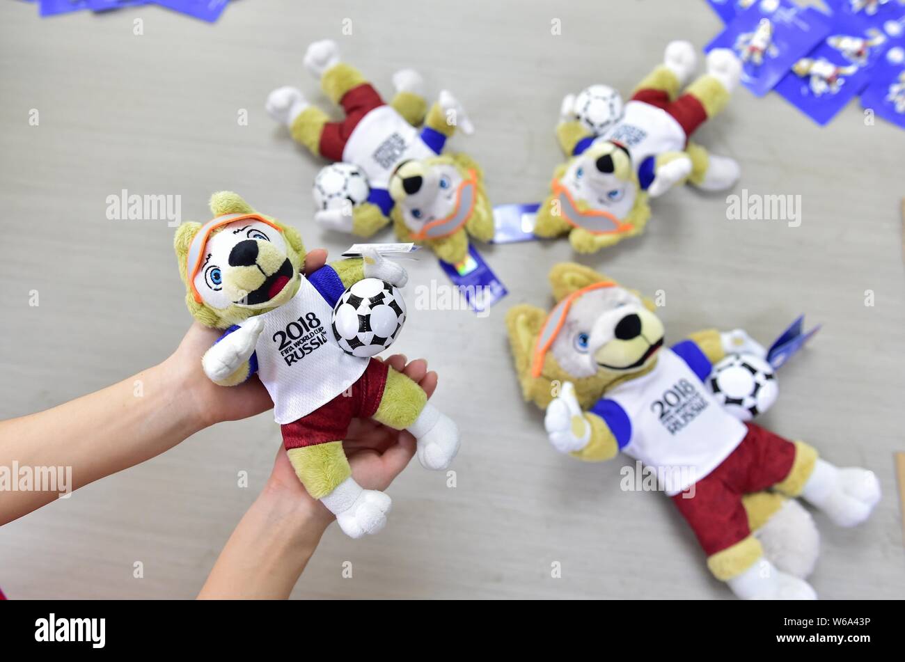 Un travailleur chinois montre une peluche sous licence d'Zabivaka le loup,  la mascotte de la Coupe du Monde FIFA 2018, à l'entrepôt d'un  transfrontalier chinois Photo Stock - Alamy