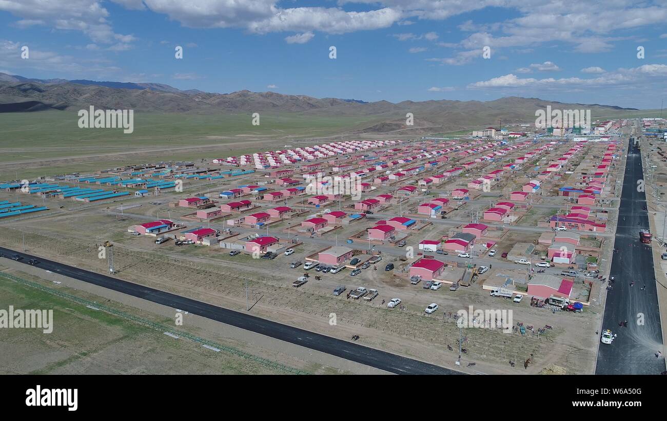 Vue aérienne de la nouvelle résidence des Kazakhs dans les toits rouges alignés sur une prairie à Yiwu county, Hami, ville du nord-ouest de la Chine Xinjiang Autonomou. Banque D'Images