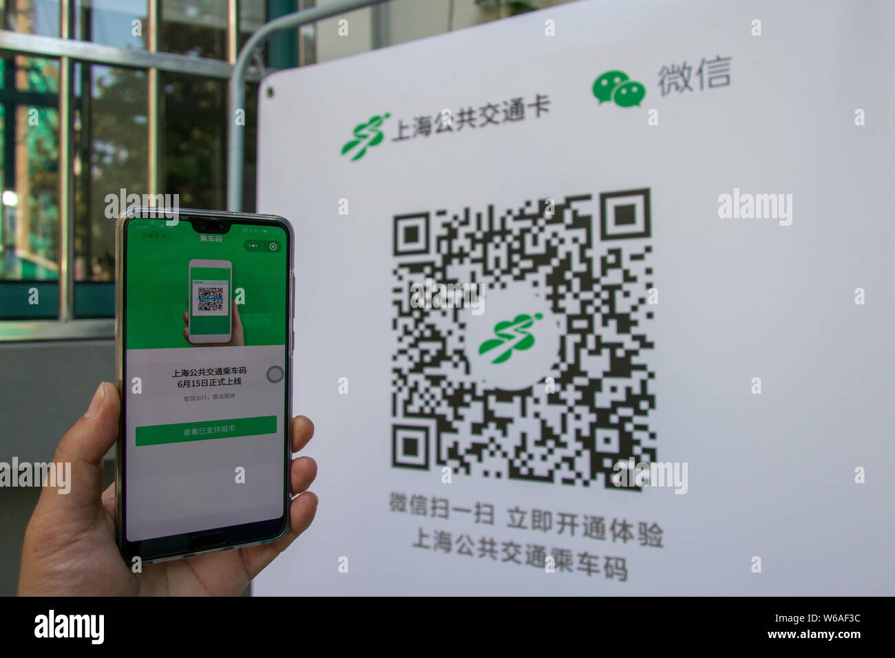 Un utilisateur de téléphone mobile chinois utilise son smartphone pour avoir l'équitation QR code scanné par l'application mobile de Tencent WeChat dans la fonction Paiement Shan Banque D'Images