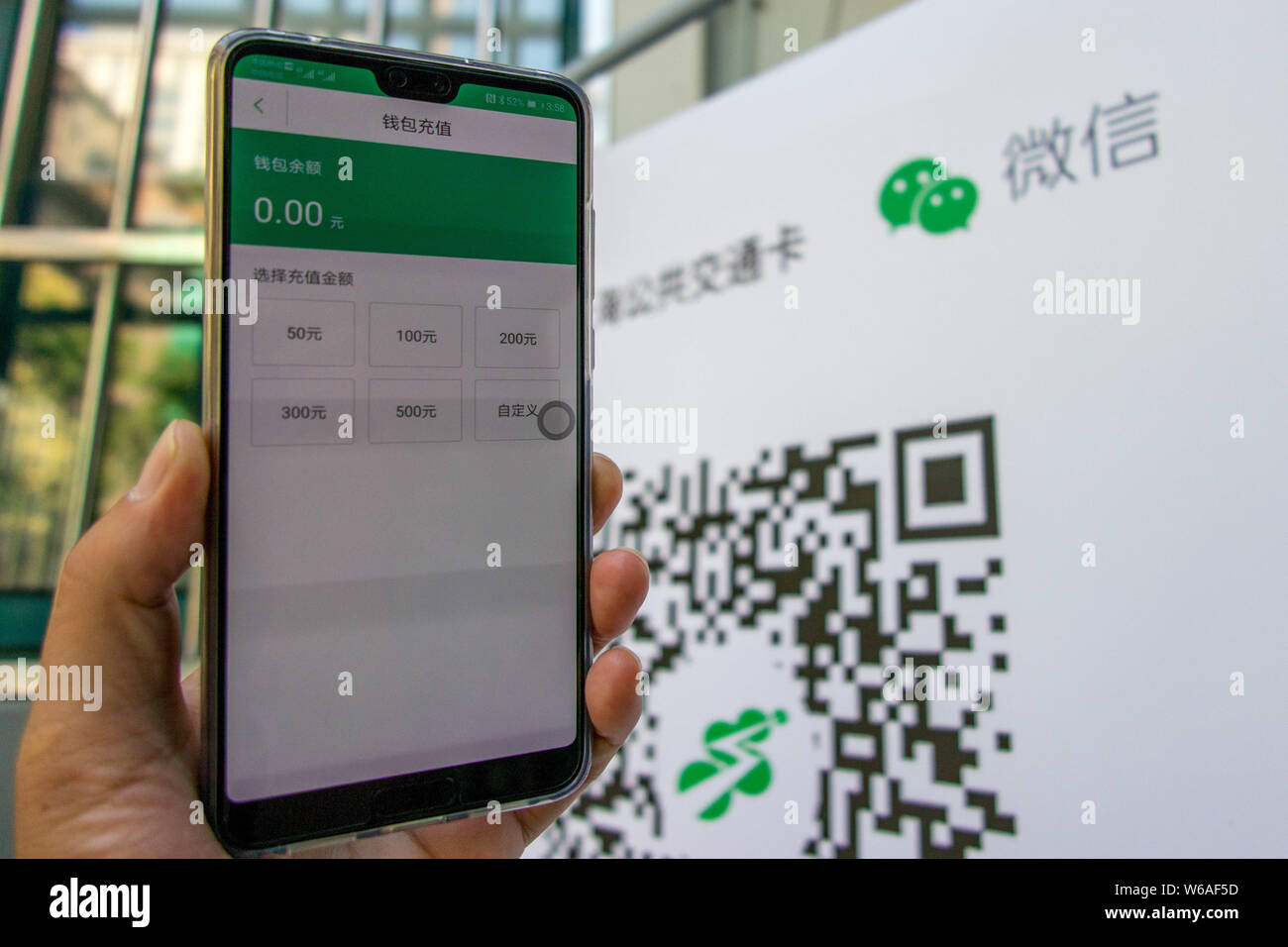 Un utilisateur de téléphone mobile chinois utilise son smartphone pour avoir l'équitation QR code scanné par l'application mobile de Tencent WeChat dans la fonction Paiement Shan Banque D'Images