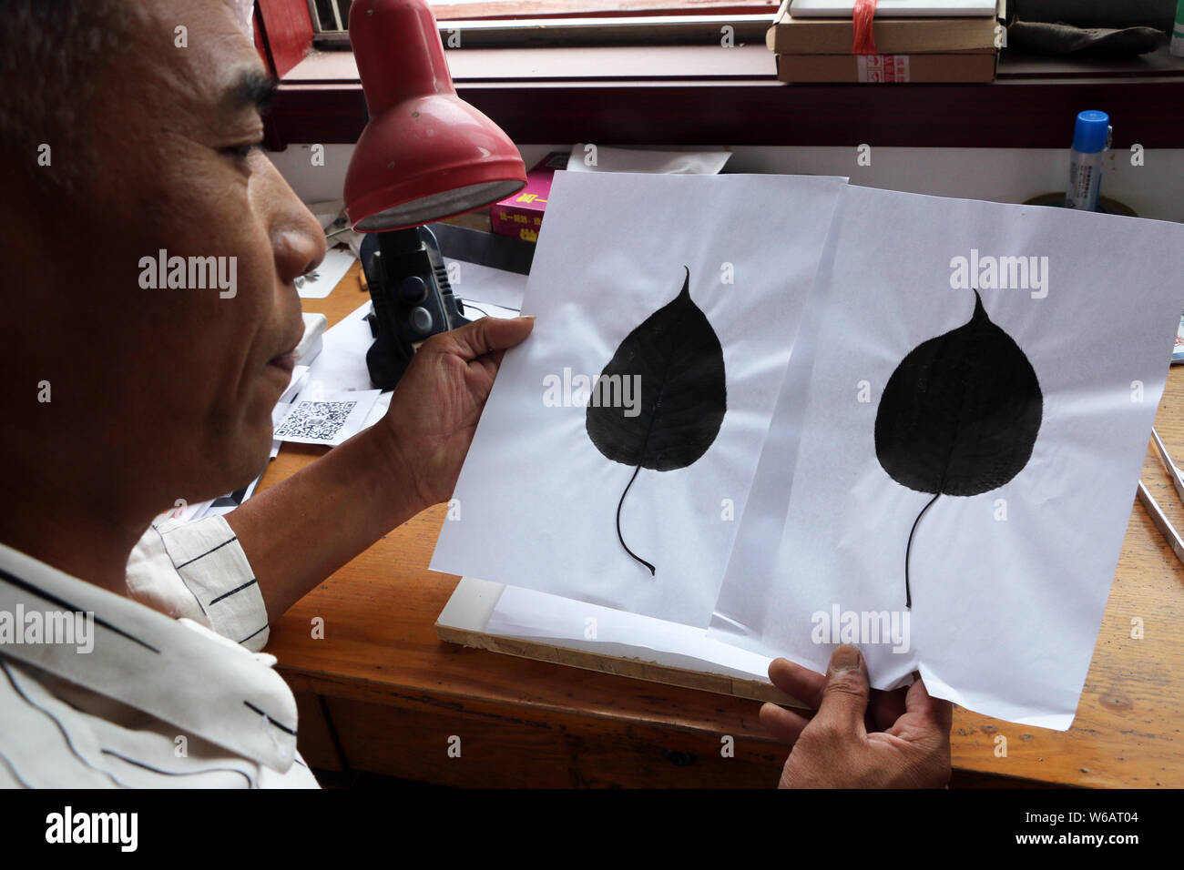 Artisan chinois Kong Qingsi chèques traités feuilles avant et son QR code de l'application messagerie Weixin, ou WeChat, de Tencent sur la surface en Banque D'Images