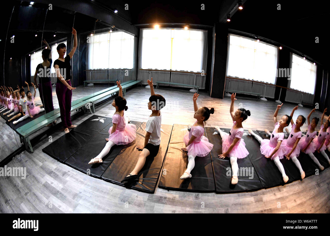 Un enseignant chinois indique à de jeunes filles et un garçon pour se dégourdir les jambes d'apprendre les compétences de danse dans un centre de formation dans la ville de Bozhou, East China's 'anhu Banque D'Images