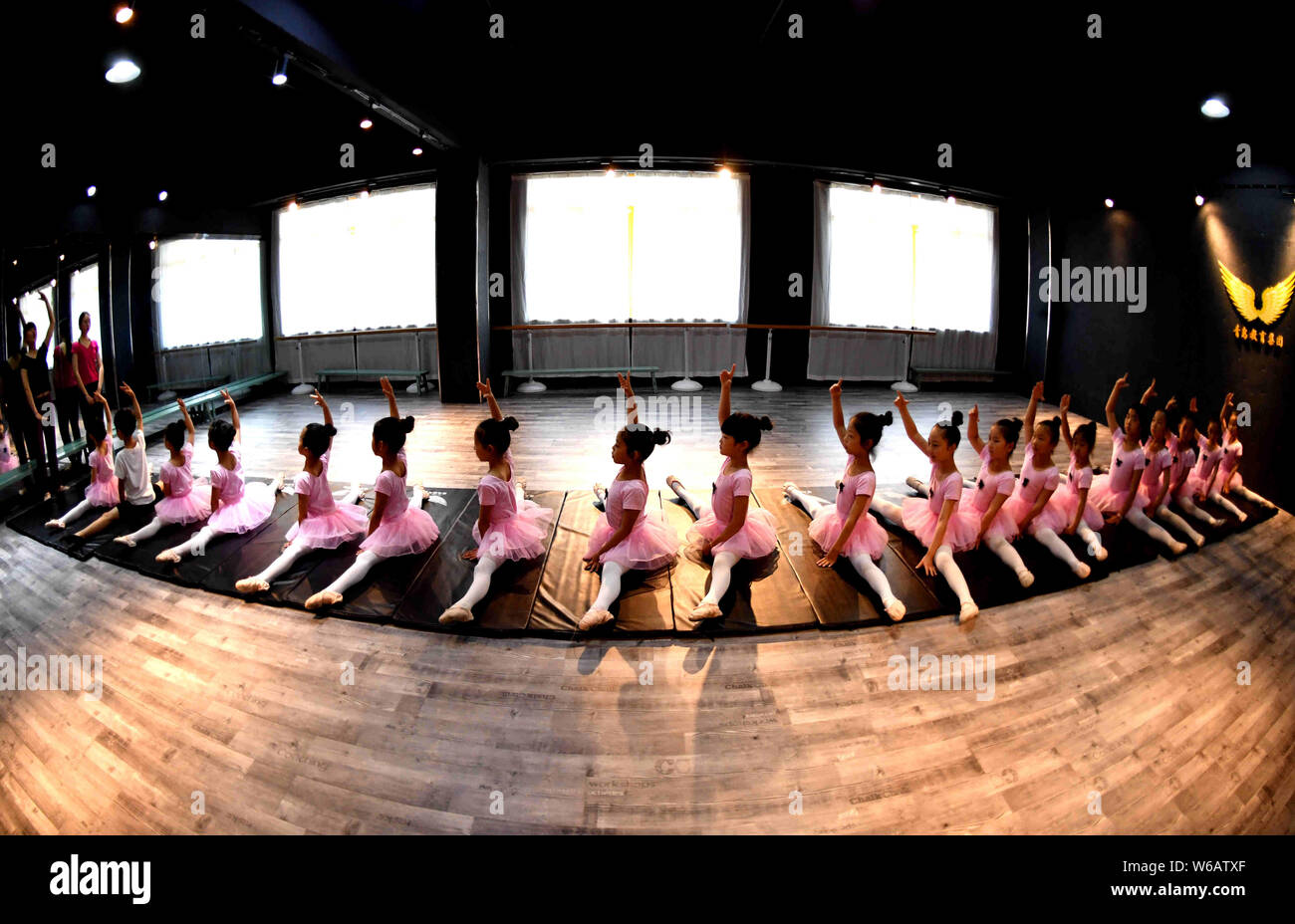Un enseignant chinois indique à de jeunes filles et un garçon pour se dégourdir les jambes d'apprendre les compétences de danse dans un centre de formation dans la ville de Bozhou, East China's 'anhu Banque D'Images