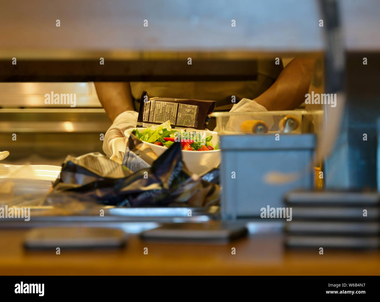 Un sac de croustilles de pommes de terre et une salade saine prêt à être livré à un restaurant de l'attente client. Banque D'Images