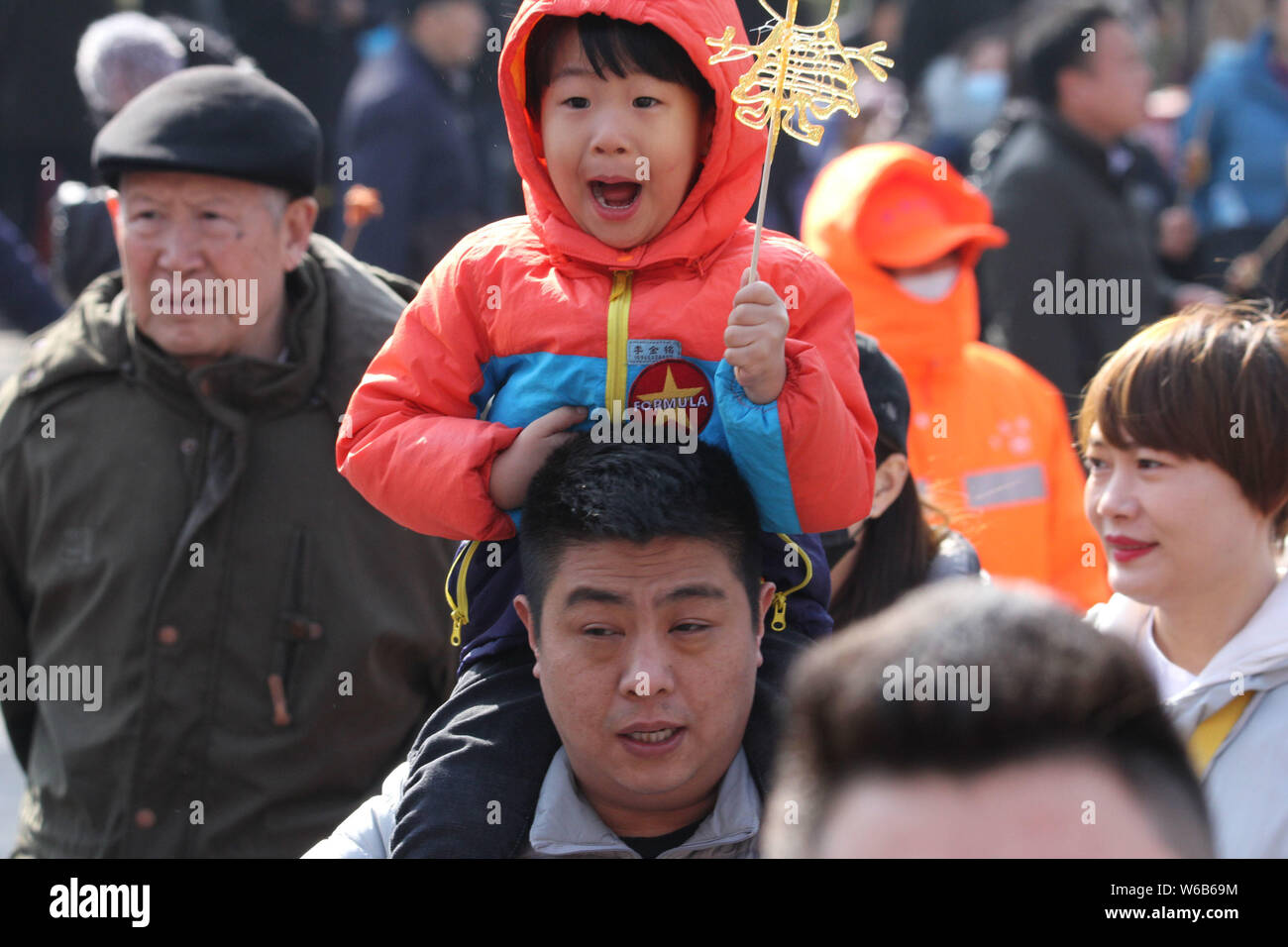 --FILE--un enfant bénéficie de la peinture comme il est assis sur l'épaule de son père dans la ville de Qingdao, province du Shandong en Chine de l'Est, 2 mars 2018. Que le chinois ch Banque D'Images