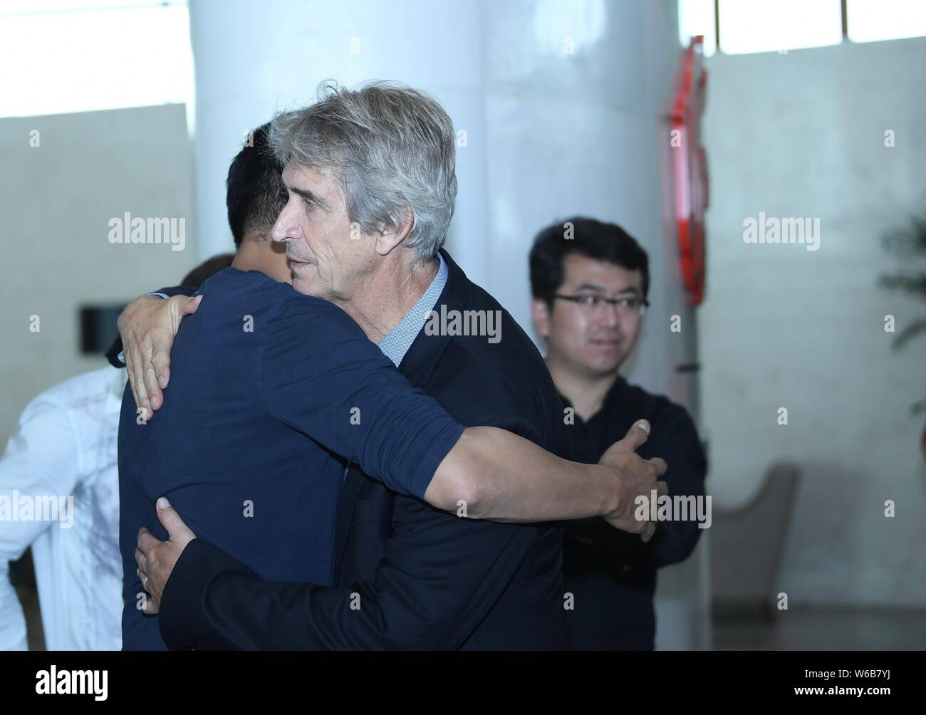 Entraîneur Manuel Pellegrini, droite, de Hebei Chine Fortune interagit avec un ventilateur chinois avant de quitter le Beijing Capital International Airport Banque D'Images