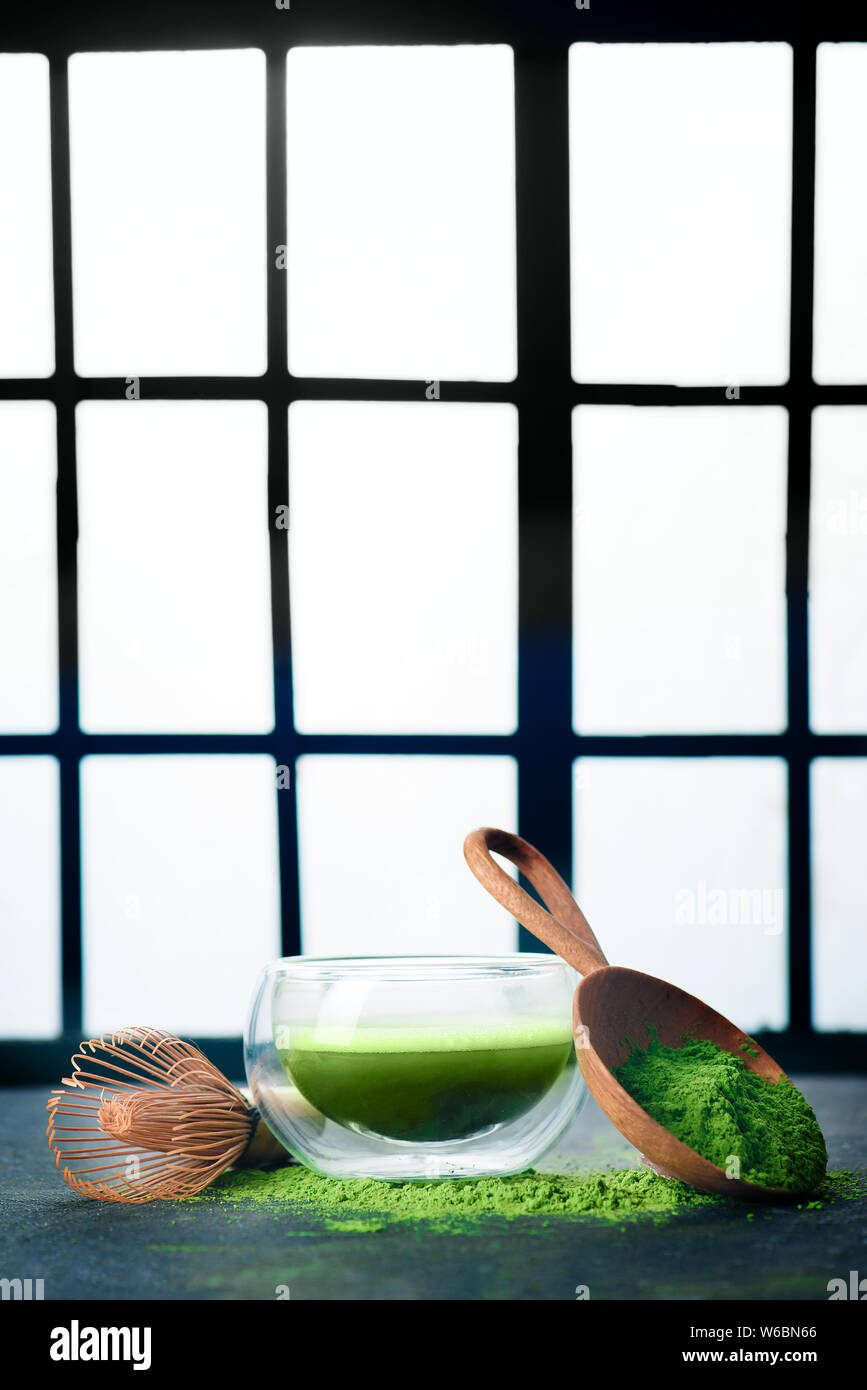 Thé vert matcha dans un bol à thé en verre double paroi avec un fouet en bambou. Arrière-plan de portes coulissantes Shoji, cérémonie traditionnelle japonaise Banque D'Images