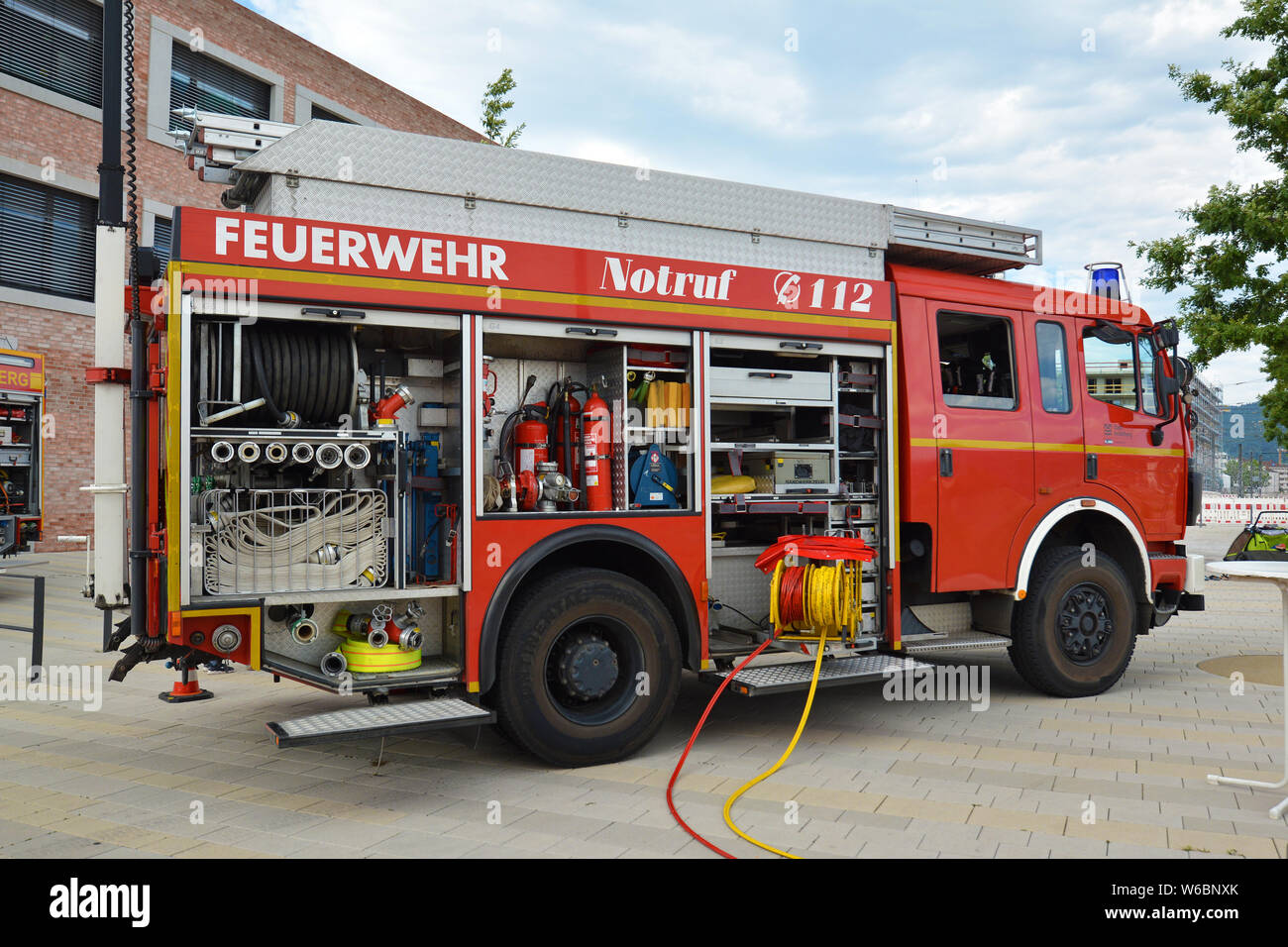 Camion de pompiers allemand rouge ouvert avec différents équipements de lutte incendie et flexibles Banque D'Images