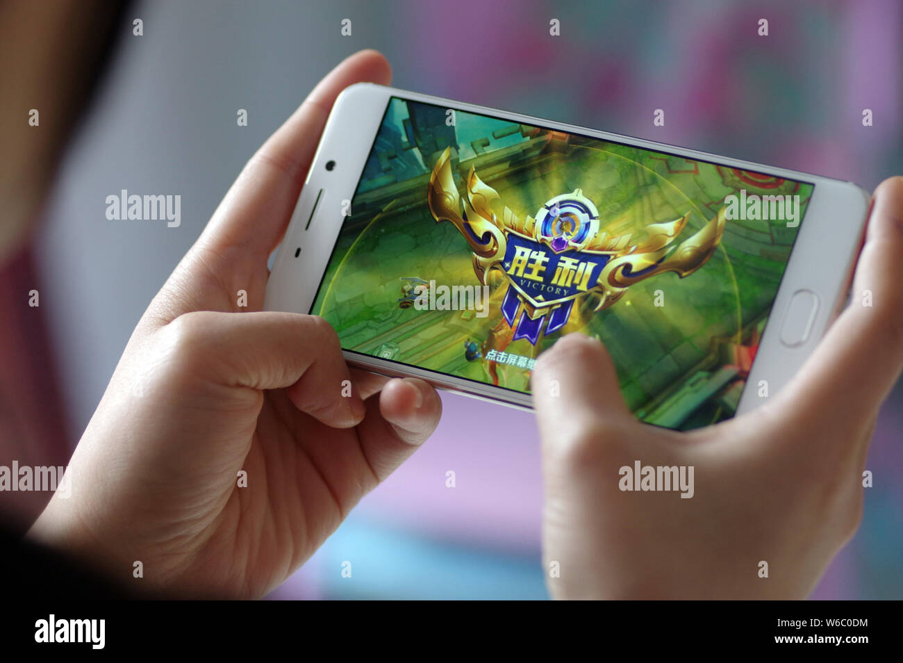 --FILE--un joueur joue le jeu mobile Chinois Tencent's mobile MOBA 'Roi de gloire' ou 'l'honneur des Rois' sur son smartphone dans la ville de Ji'nan, de l'Est Chine Sh Banque D'Images