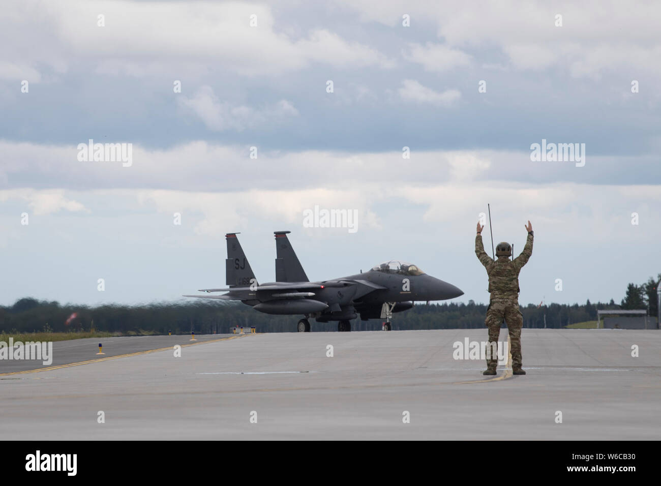 Un U.S. Air Force Special Tactics maréchaux de l'opérateur un F-15E Strike Eagle au cours d'un avion de chasse de l'avant et d'armement essence mission dans le cadre de l'exercice Opération Forge rapide sur la base aérienne d'Āmari, l'Estonie, le 16 juillet 2019. Special Tactics est une opération spéciale du Commandement aérien tactique et de masse, la force d'intégration et de l'Air Force d'opérations spéciales des forces au sol, accès, leader mondial de la grève de précision, la récupération du personnel et les opérations de chirurgie de bataille sur le champ de bataille. Le F-15E Strike Eagle est un double-rôle fighter conçu pour effectuer l-air et air-sol, missions, Banque D'Images