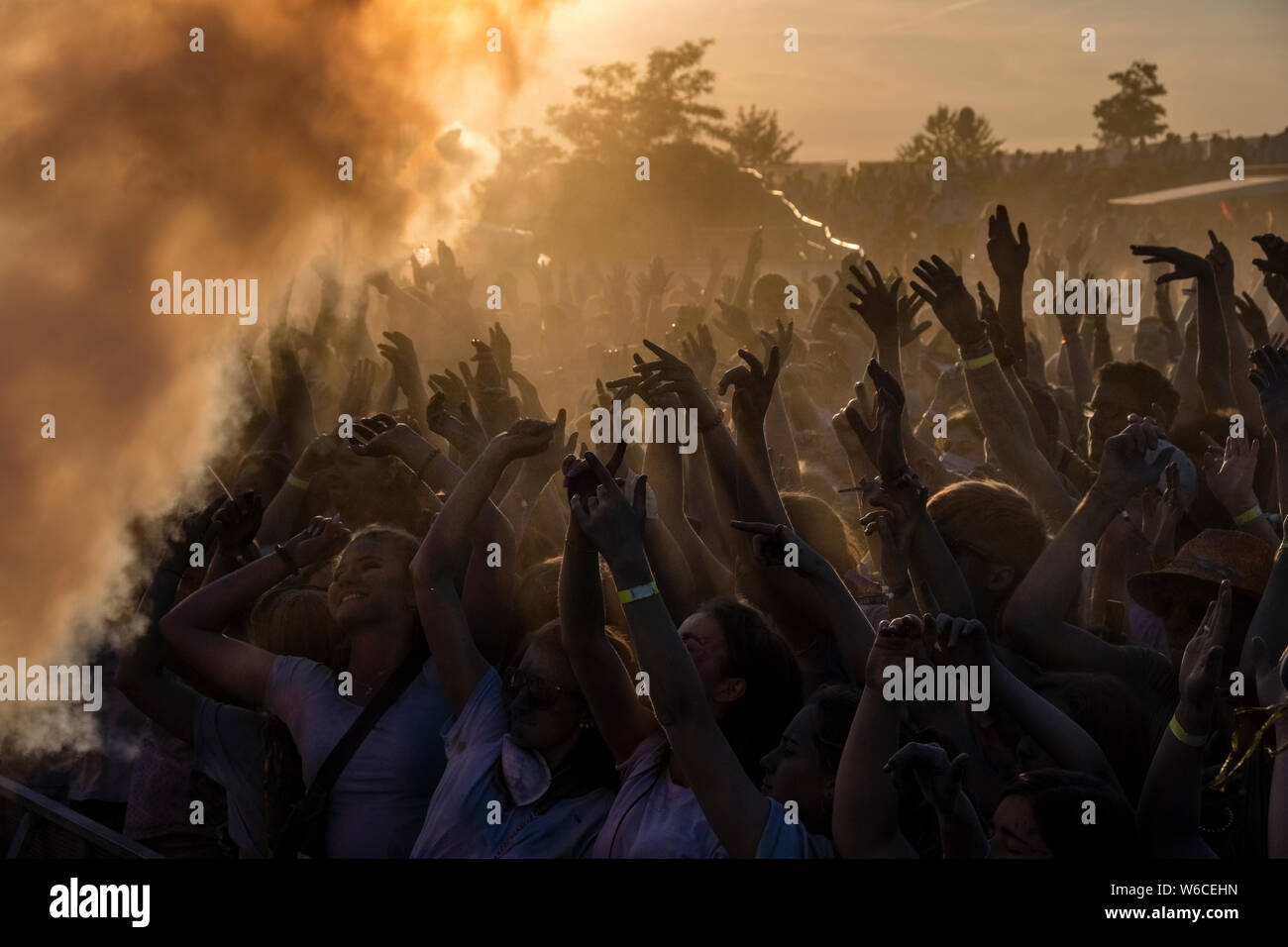 Des centaines de jeunes gens célèbrent Holi, le Festival des couleurs, au coucher du soleil Banque D'Images