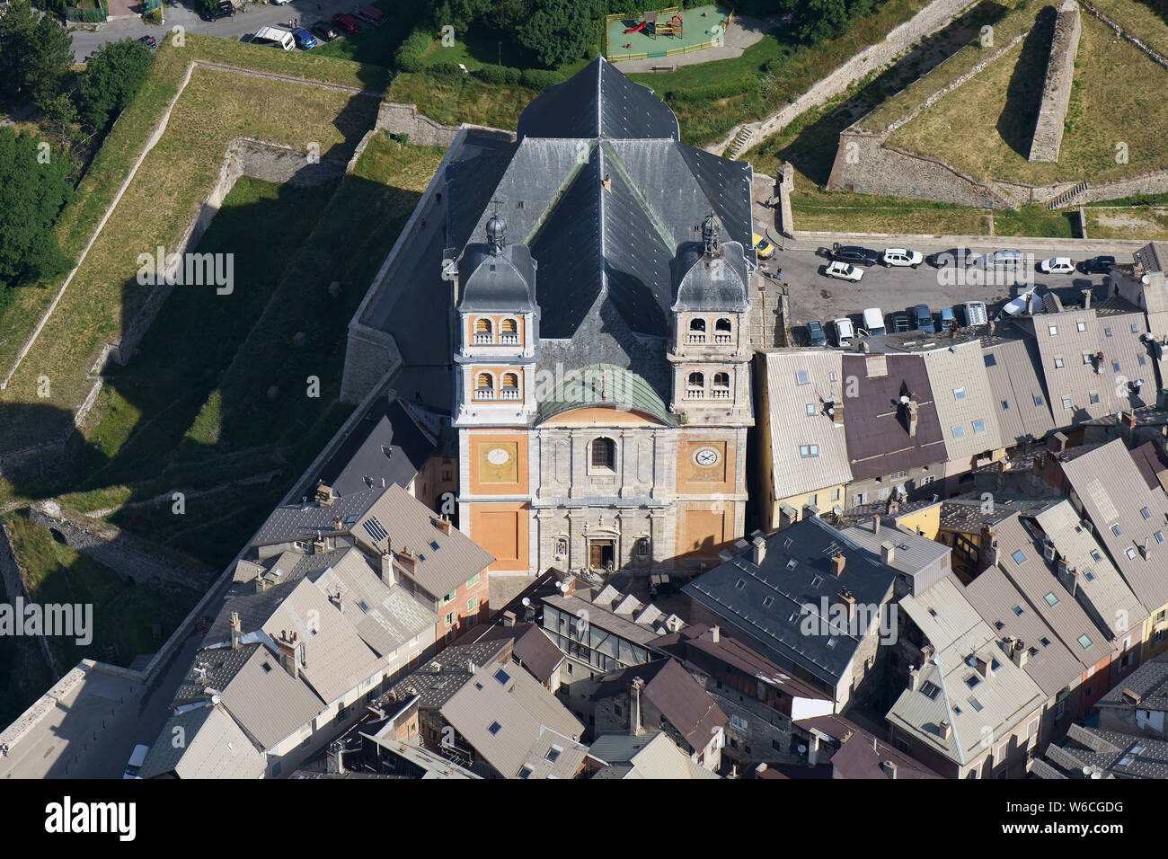 VUE AÉRIENNE. Collégiale notre-Dame et Saint-Nicolas donnant sur les toits de la vieille ville. Briançon, Hautes-Alpes, France. Banque D'Images