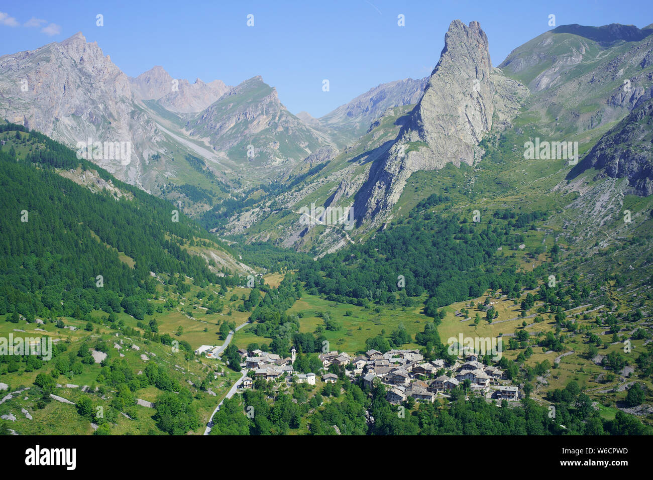 VUE AÉRIENNE. Dernier village (alt.: 1650M) de la haute vallée de Maira et de son proéminent 'Rocca Provenzale' (alt.: 2451m). Chiapppera, Piémont, Italie. Banque D'Images