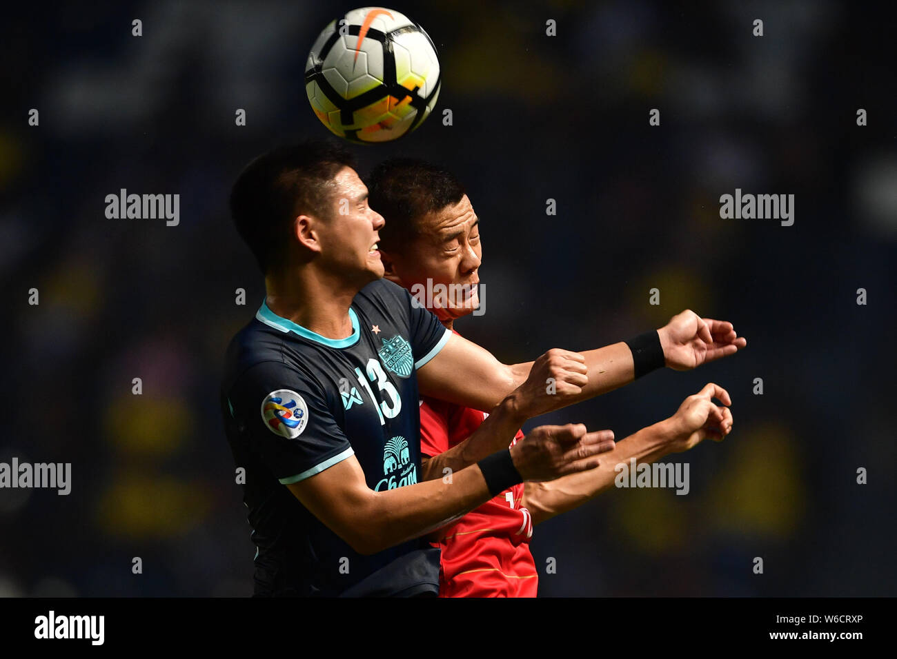 Narubadin Weerawatnodom, gauche, de Thaïlande Buriram United FC est à la tête de la balle contre Huang Bowen de Chine Guangzhou Evergrande FC de Taobao dans un groupe Banque D'Images