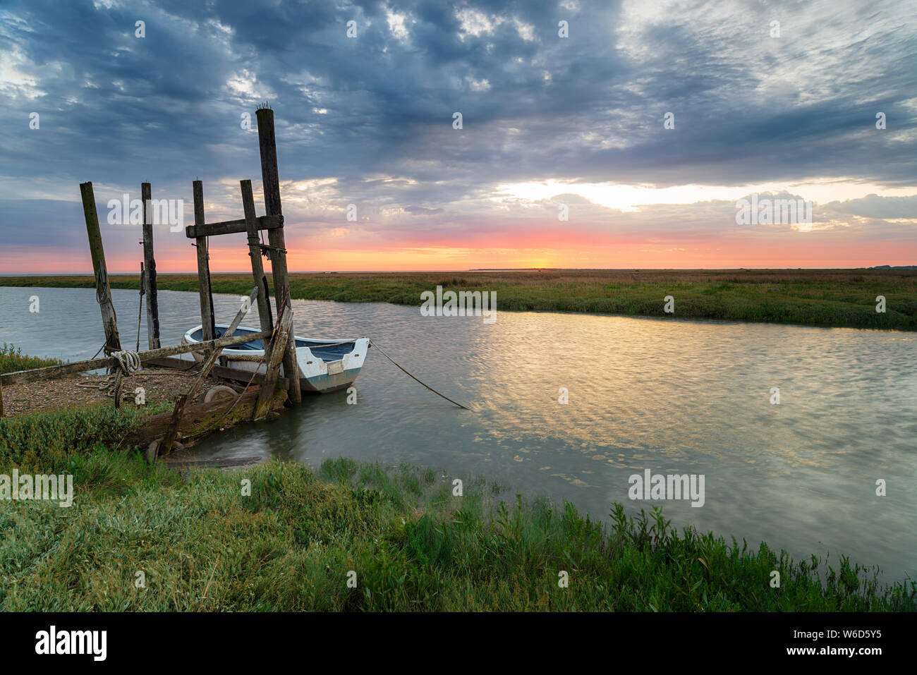 Le lever du soleil sur un bateau amarré à un vieux quai en bois à Thornham sur la côte de Norfolk Banque D'Images Le lever du soleil sur un bateau amarré à un vieux quai en bois à Thornham sur la côte de Norfolk Banque D'Images