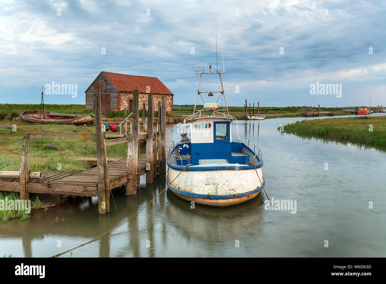Un bateau de pêche amarré à une jetée wodden à Thornham sur la côte de Norfolk Banque D'Images Un bateau de pêche amarré à une jetée wodden à Thornham sur la côte de Norfolk Banque D'Images