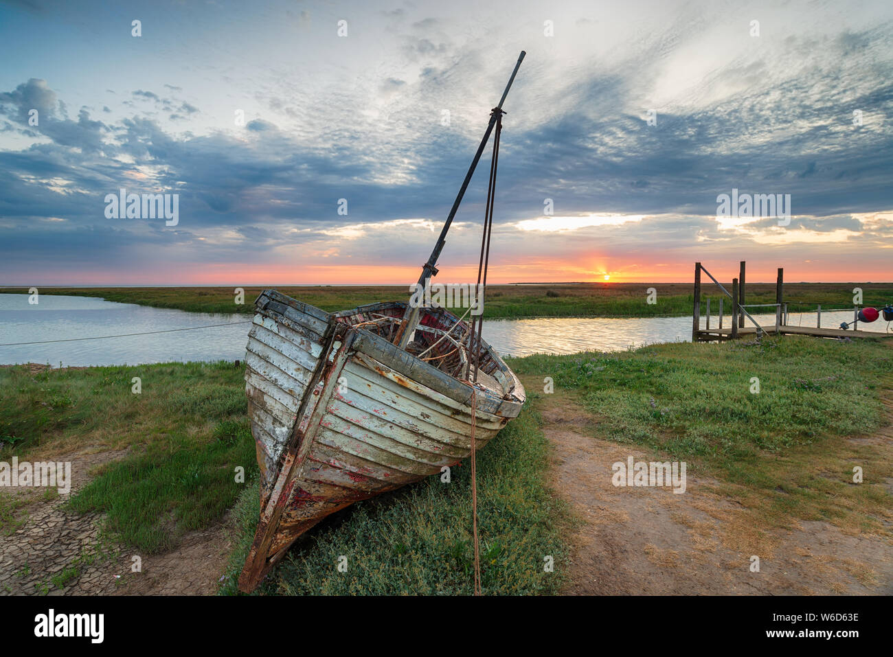 Lever de Soleil sur le bateau de pêche abandonné sur la berge à Thornham sur la côte nord de Norfolk Banque D'Images Lever de Soleil sur le bateau de pêche abandonné sur la berge à Thornham sur la côte nord de Norfolk Banque D'Images