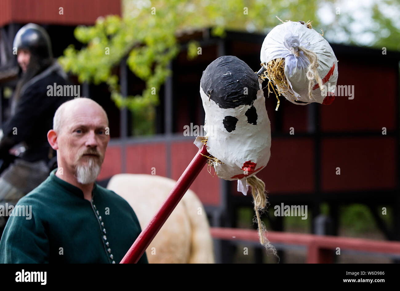 Un adjoint d'un knight montre deux têtes qui le chevalier butts avec sa lance au cours d'un tournoi de joutes en plein air, dans le centre médiéval de Nykøbing Falster, Danemark. Avant la tête artificielle a été introduit dans les temps anciens du vrai chefs d'ennemis décapités ou des criminels a été utilisé. Le centre médiéval est un musée vivant, expérimental qui illustre le Moyen Âge danois à la 14e et 15e siècle. Il est conçu comme une ville typique marché danois avec des artisans, un port avec bateaux et navires, et une place de marché. Le Centre d'employés et de bénévoles sont habillés en costumes de l'époque, ils liv Banque D'Images