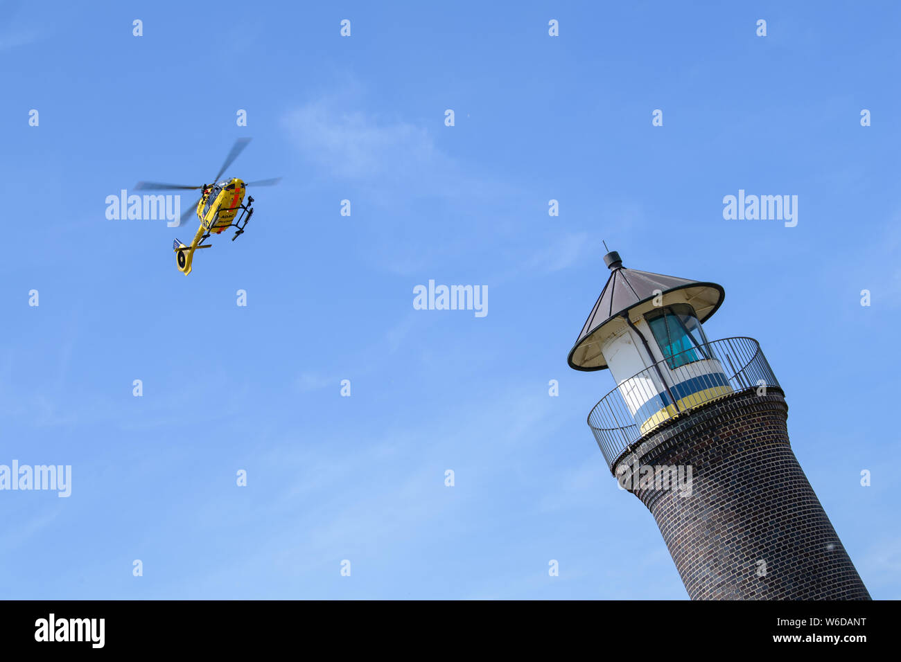 Juist, Allemagne. 26 juillet, 2019. Un hélicoptère de l'ADAC Luftrettung commence derrière le phare de l'île de Juist. Credit : Matthias Balk/dpa/Alamy Live News Banque D'Images