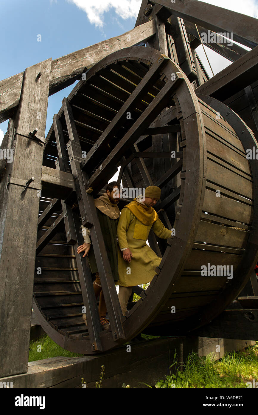 Les soldats travaillent la roue sur le trébuchet pour lancer son bras est armé et prêt à être envoyé au centre médiéval de plein air à Nykøbing Falster, Danemark. Trébuchets a été utilisé au cours du Moyen Âge par assiégeants à bombarder une forteresse ou une ville en jetant des pierres, boules de feu et d'autres éléments dommageables et à l'ennemi. Les points qui pourraient démoraliser l'ennemi pourrait être utilisé, comme un porc pourri ou une vache qui pourraient causer des maladies. Un espion capturés sont très pratiques, en apportant d'autres espions potentiels revenir sur leur entreprise. Nykøbing Falster centre médiéval a deux trébuchets reconstruit. Banque D'Images