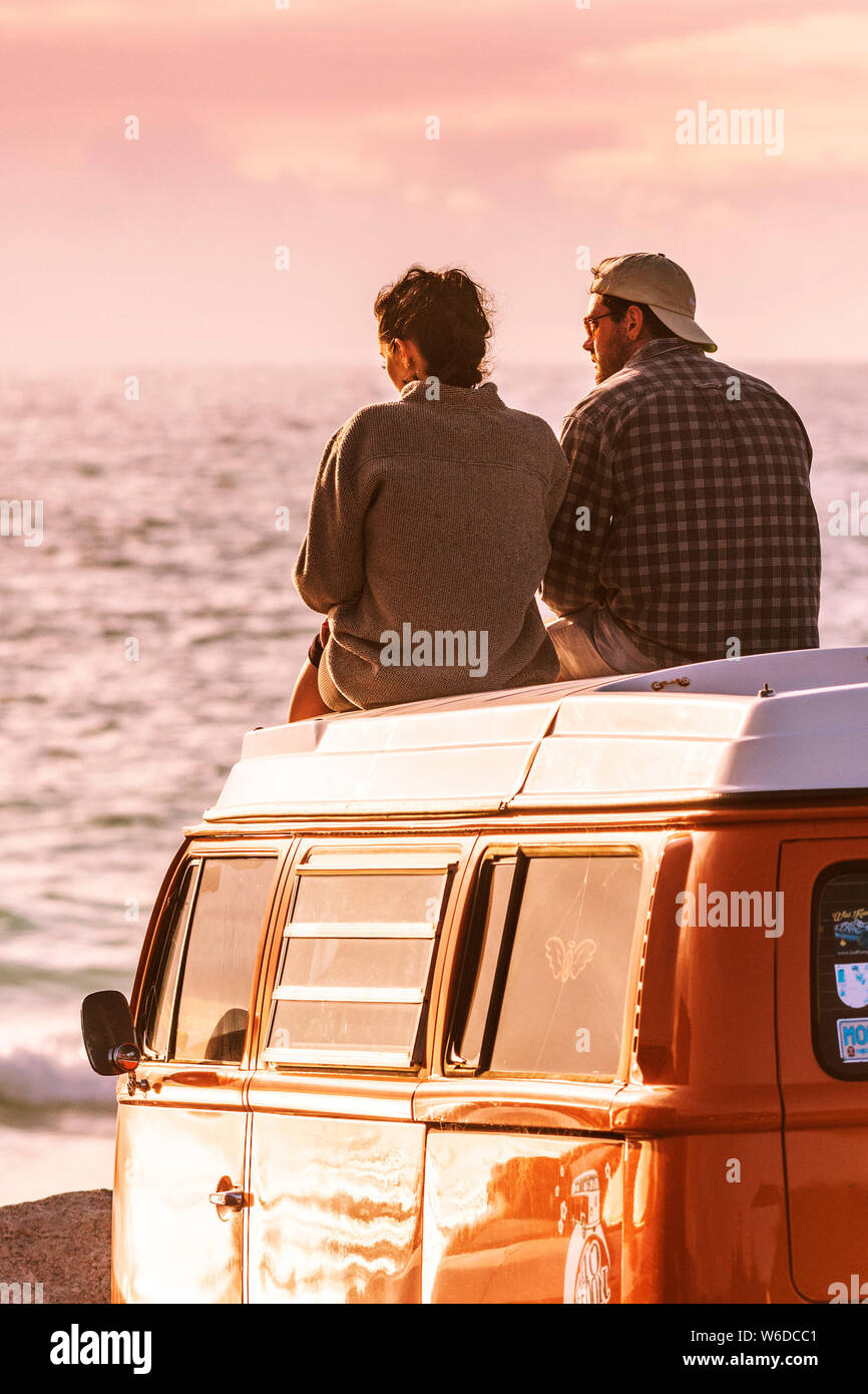 Un couple assis sur le dessus de leur camping-car Volkswagen VW profitant de la lumière du soir à dans Fistral Newquay en Cornouailles. Banque D'Images