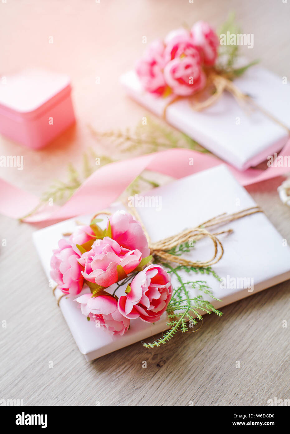 Composition avec boîtes cadeaux décorées de branches vertes et de roses. Banque D'Images