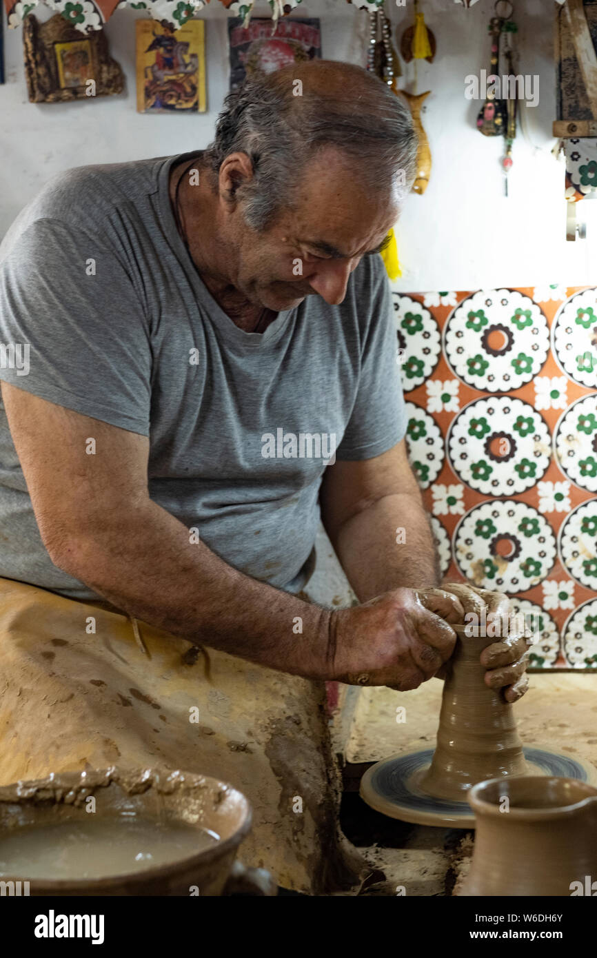 Portrait d'un vieux potter au travail à sa roue faisant de la poterie en céramique dans le style traditionnel de l'île de Lesbos, Grèce Banque D'Images