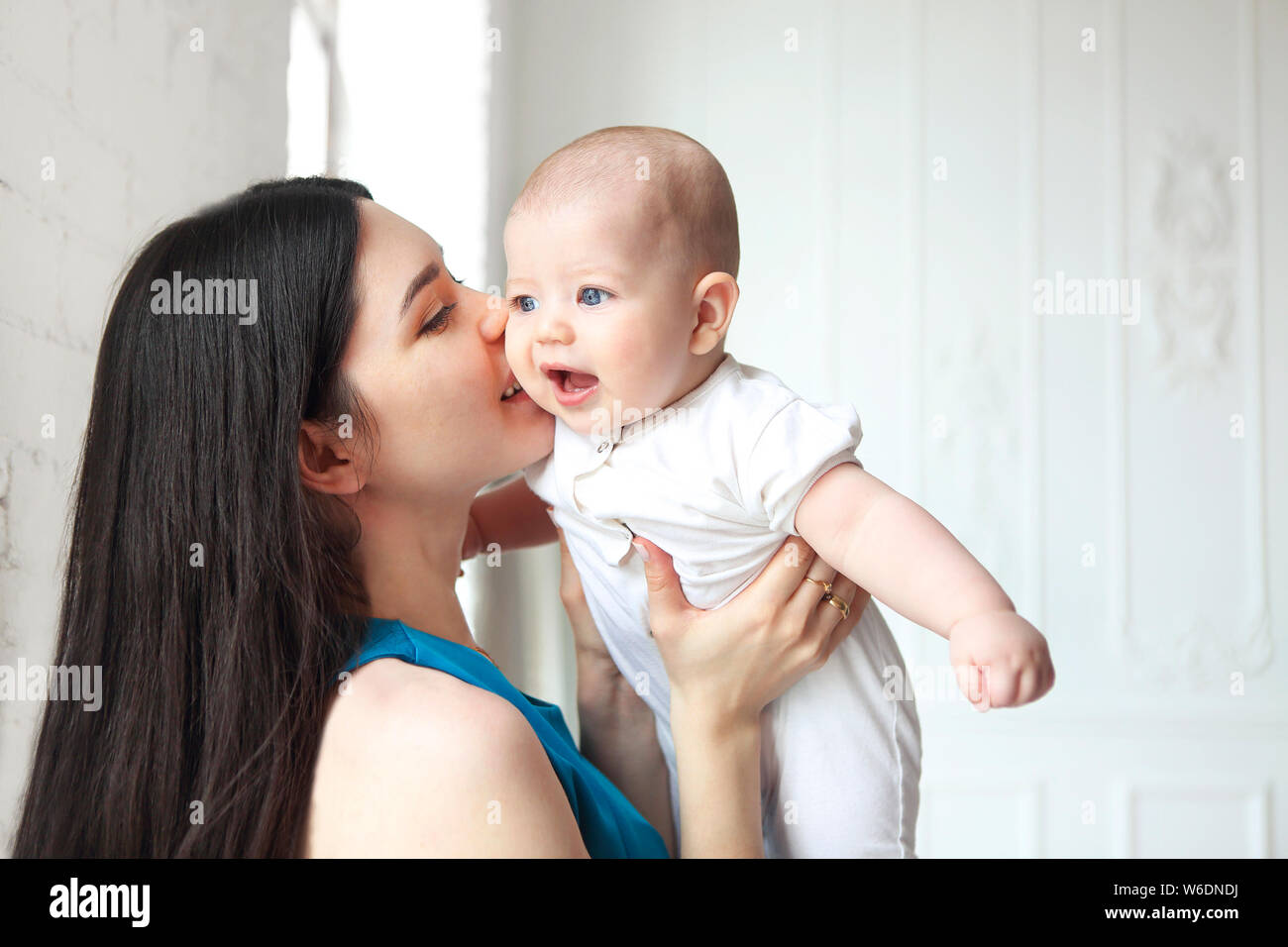 Jeune belle mère holding sweet baby boy sur ses mains Banque D'Images