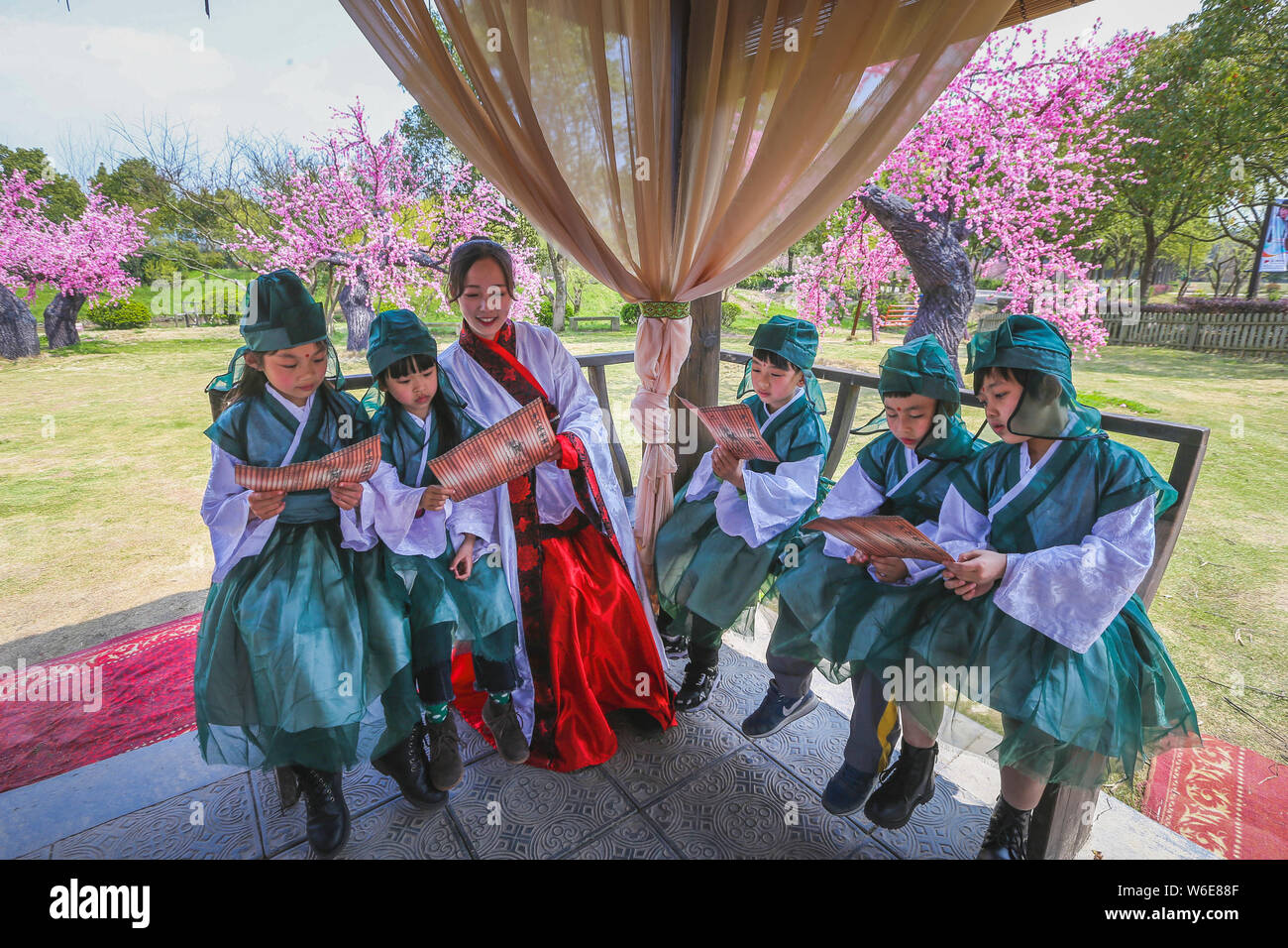 Des étudiants chinois, vêtus de costumes traditionnels lire dans les classiques chinois Ningbo City, Zhejiang Province de Chine orientale, le 23 mars 2018. Banque D'Images
