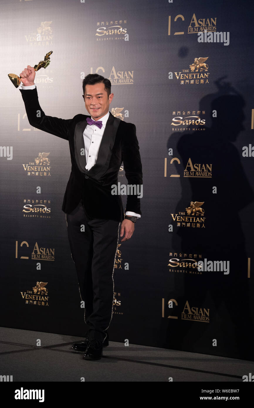 Hong Kong, chanteur et acteur Louis Koo contient jusqu'son trophée après avoir remporté le Prix du Meilleur Acteur pour son film 'paradoxe' lors de la 12e Asian Film Awards Banque D'Images