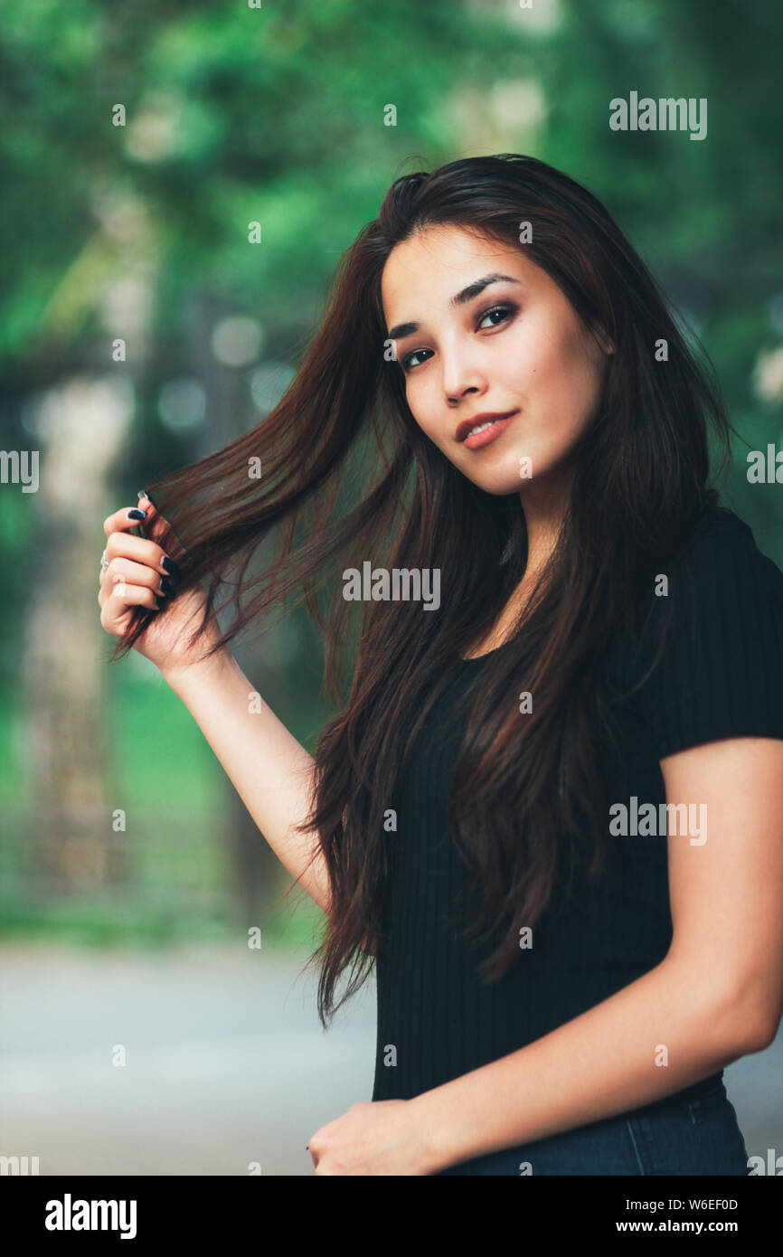 Portrait of beautiful happy long hair asian girl in black t-shirt dans la rue Banque D'Images