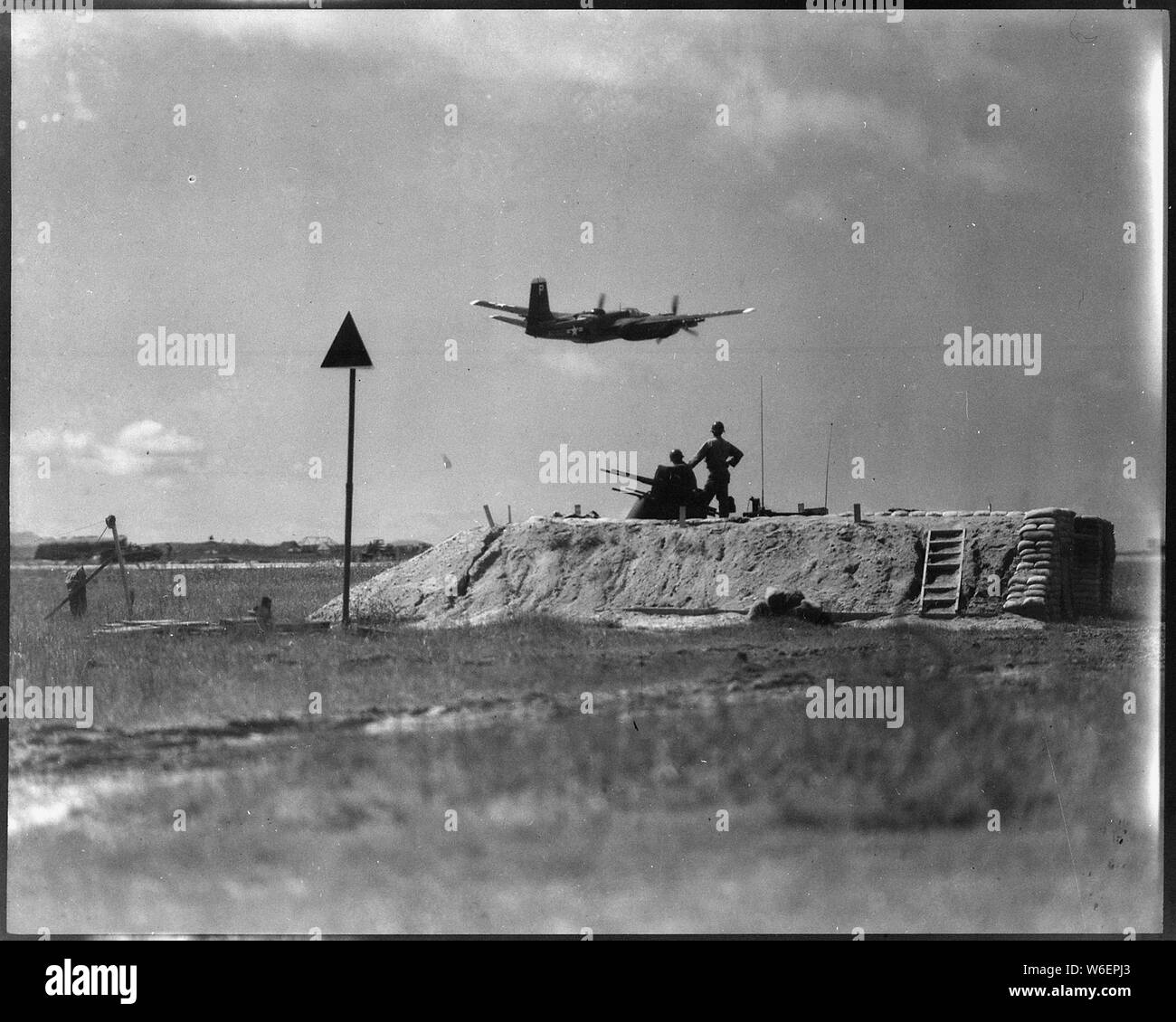 Un B-26 de l'US Air Force de bombardier léger prend le ciel sur une autre grève contre des cibles militaires communistes comme un anti-aircraft crew montres. Les bombardiers légers volent des missions de jour et de nuit, de transport et d'approvisionnement de l'ennemi d'attaquer des cibles. L'équipage se tenir en tout temps regarder pour protéger la base en cas d'attaque aérienne ennemie. Banque D'Images