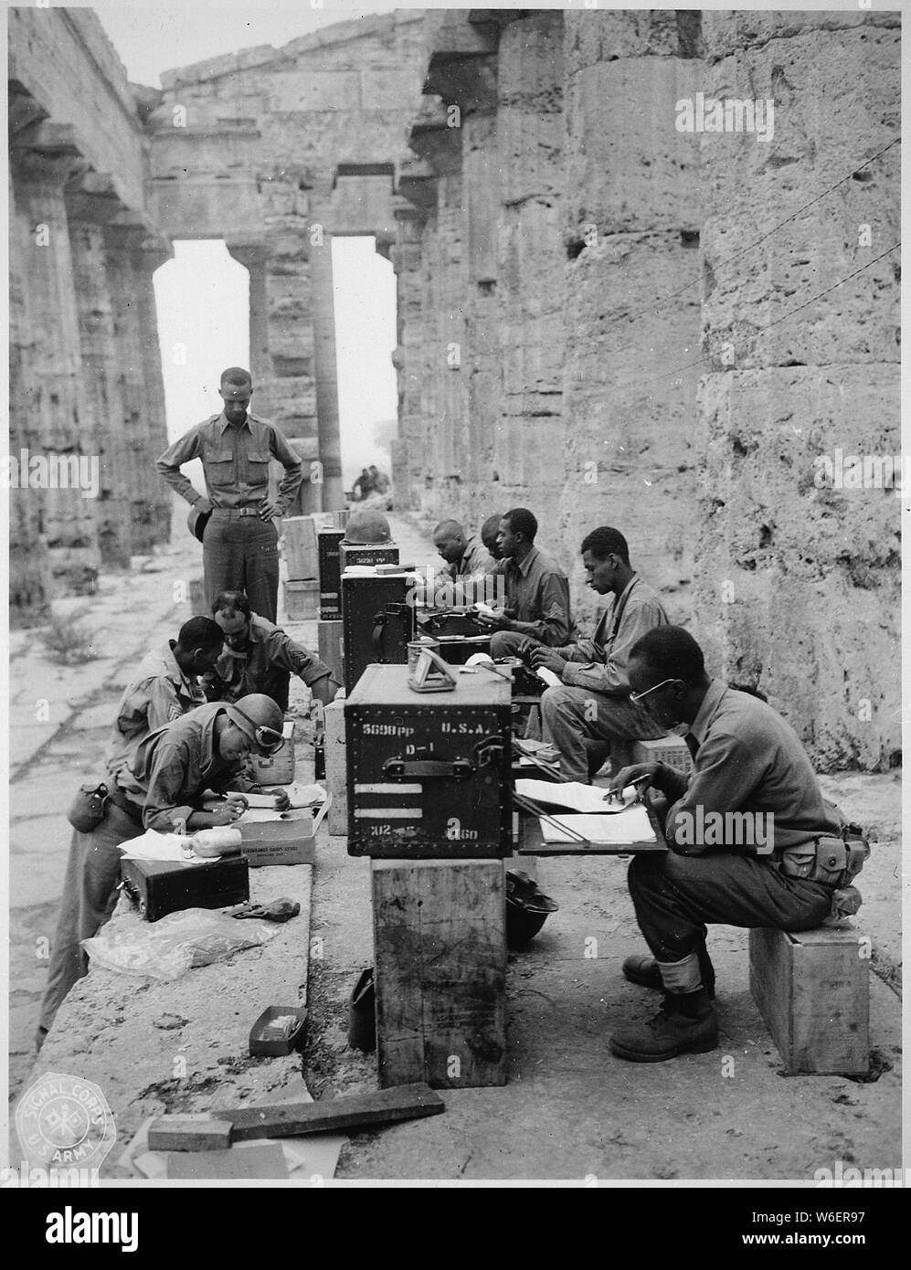 Une société d'hommes a son bureau entre les colonnes doriques) (d'un ancien temple grec de Neptune, construit vers 700 av. J.-C., 09/22/1943 ; Portée et contenu : à 24, l'avant à l'arrière : sgt. James Shellman, Gilbert A. Terry, John W., Phoenix Curtis A. Richardson, et Leslie B. Wood. En face du bureau, de l'avant vers l'arrière : T/Sgt. Gordon A. Scott, M/Sgt. Walter C. Jackson, Sgt. David D. Jones, et l'ADJ Carlyle M. Tucker. L'Italie. Banque D'Images