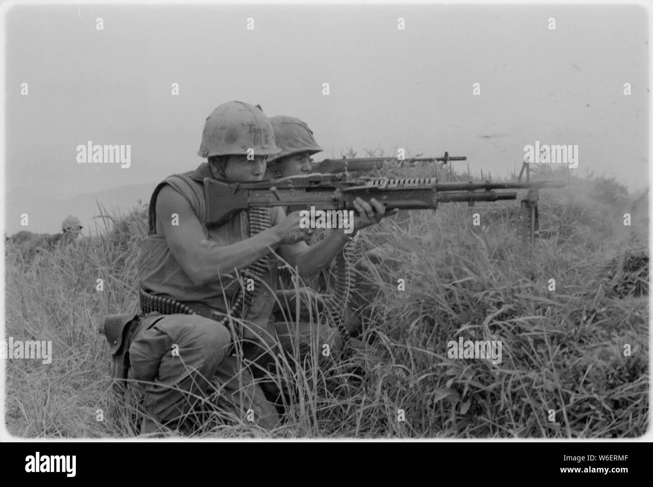 Une machine gunner et un carabinier du 5ème Régiment de Marines le feu sur l'ennemi près de la zone démilitarisée au Vietnam. Banque D'Images