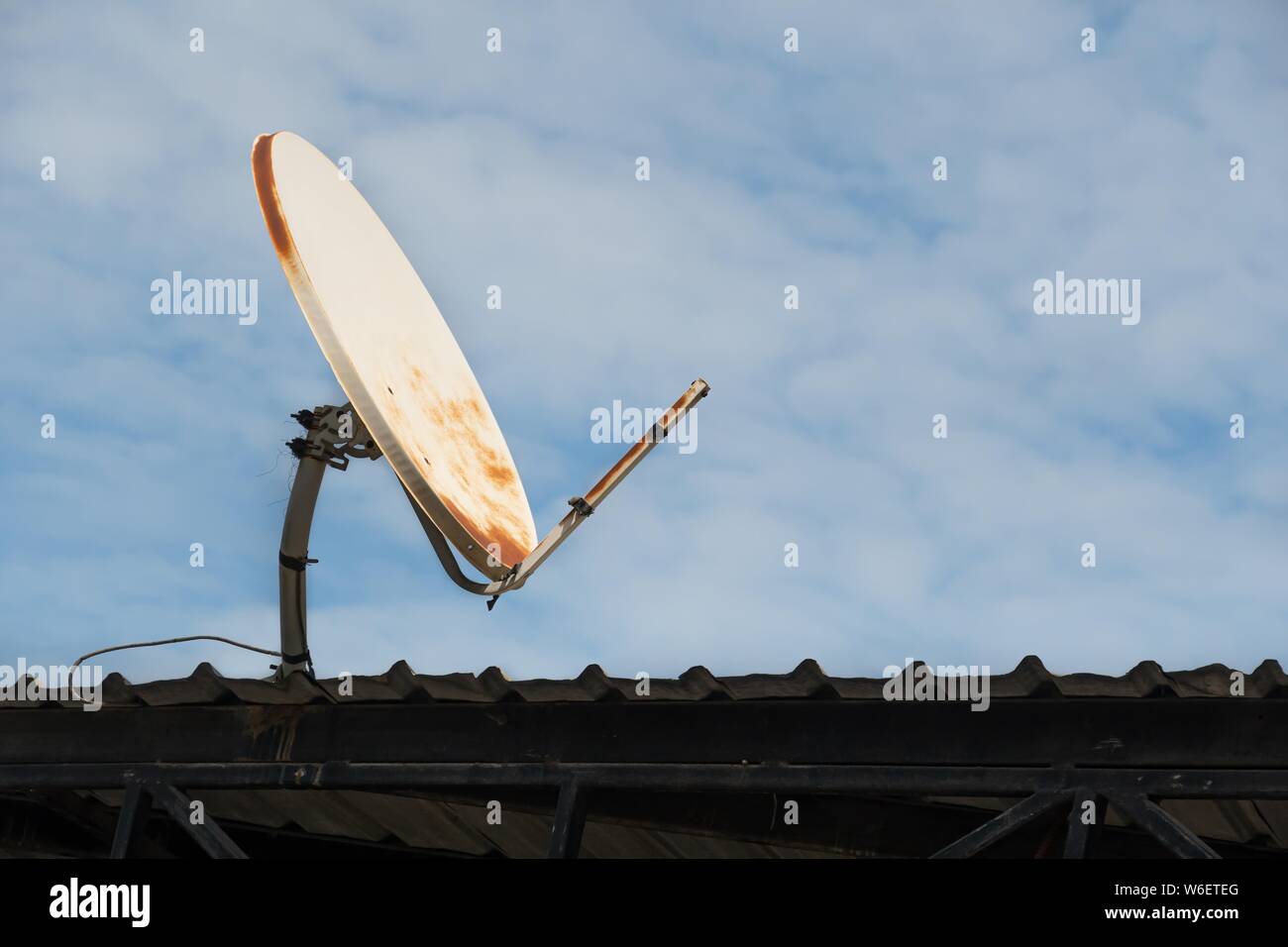 Brisée et vieille antenne satellite sur le toit et fond de ciel bleu. Banque D'Images