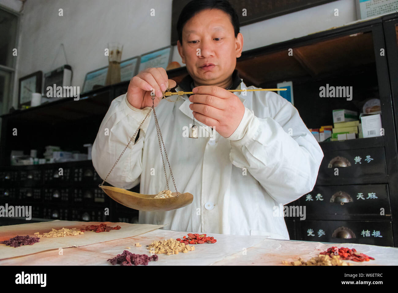 --FILE--une pharmaceutist chinois pèse des herbes médicinales dans une clinique de Tangyin county, ville d'Anyang, province du Henan en Chine centrale, 4 novembre 2013. Banque D'Images