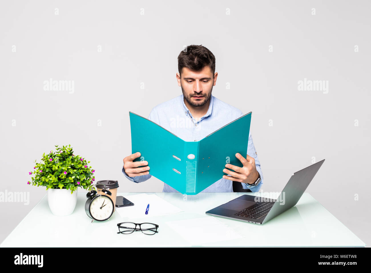 Happy businessman holding folder avec documents et smiling in office Banque D'Images