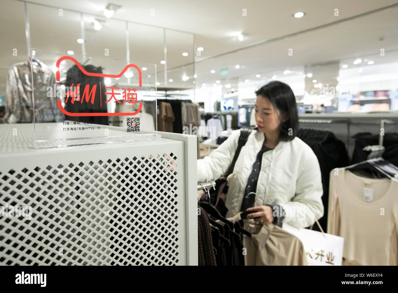 Un logo de détaillant de mode H&M et le site d'achat en ligne de Tmall.com  e-commerce chinois Alibaba Group géant est représenté à un magasin H & M  dans Shangha Photo Stock -