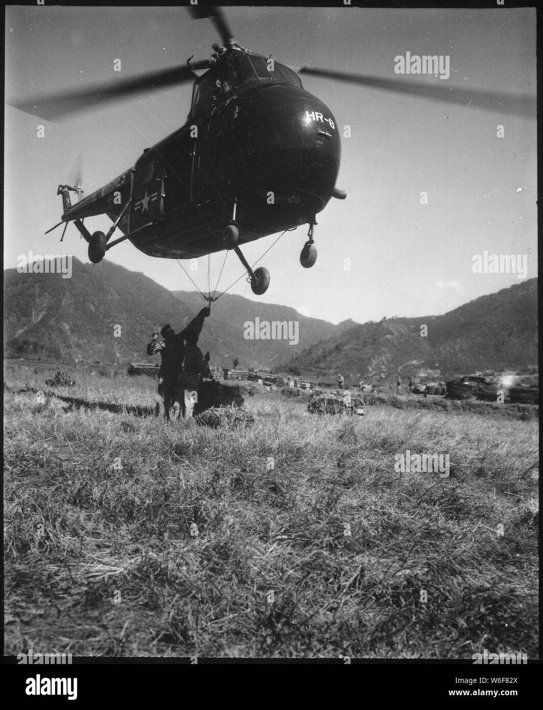 Un hélicoptère Sikorsky H-1 en vol stationnaire près du sol tandis qu'un filet crochet Marines chargé avec 1 000 livres de fournitures pour le transport à l'avant à 19 kilomètres. ; notes générales : utilisation de la guerre et des conflits Nombre 1410 lors de la commande d'une reproduction ou demande d'informations sur cette image. Banque D'Images Un hélicoptère Sikorsky H-1 en vol stationnaire près du sol tandis qu'un filet crochet Marines chargé avec 1 000 livres de fournitures pour le transport à l'avant à 19 kilomètres. ; notes générales : utilisation de la guerre et des conflits Nombre 1410 lors de la commande d'une reproduction ou demande d'informations sur cette image. Banque D'Images