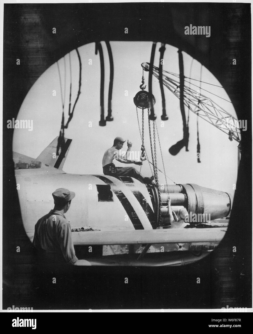 Une équipe de maintenance des aéronefs de l'US Air Forces canadiennes 4e Escadre Fighter-Interceptor en Corée, photographié par la tuyère d'échappement d'un F-86 Sabre, monte un moteur en place pour l'installation sur l'un des avions de combat à réaction. ; notes générales : utilisation de la guerre et des conflits Nombre 1411 lors de la commande d'une reproduction ou demande d'informations sur cette image. Banque D'Images Une équipe de maintenance des aéronefs de l'US Air Forces canadiennes 4e Escadre Fighter-Interceptor en Corée, photographié par la tuyère d'échappement d'un F-86 Sabre, monte un moteur en place pour l'installation sur l'un des avions de combat à réaction. ; notes générales : utilisation de la guerre et des conflits Nombre 1411 lors de la commande d'une reproduction ou demande d'informations sur cette image. Banque D'Images