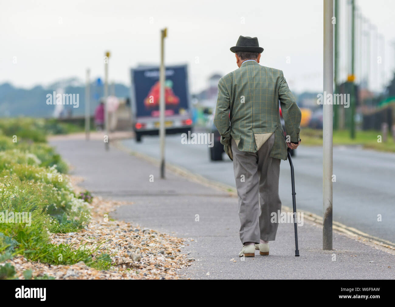 Man Walking tout en utilisant un bâton de marche au Royaume-Uni. Banque D'Images