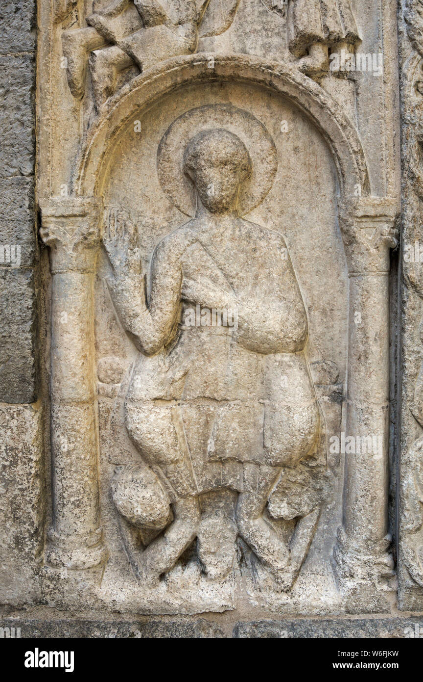 La figure religieuse ancienne sur la façade extérieure d'une église médiévale (basilique San Fedele à Côme, Italie) Banque D'Images
